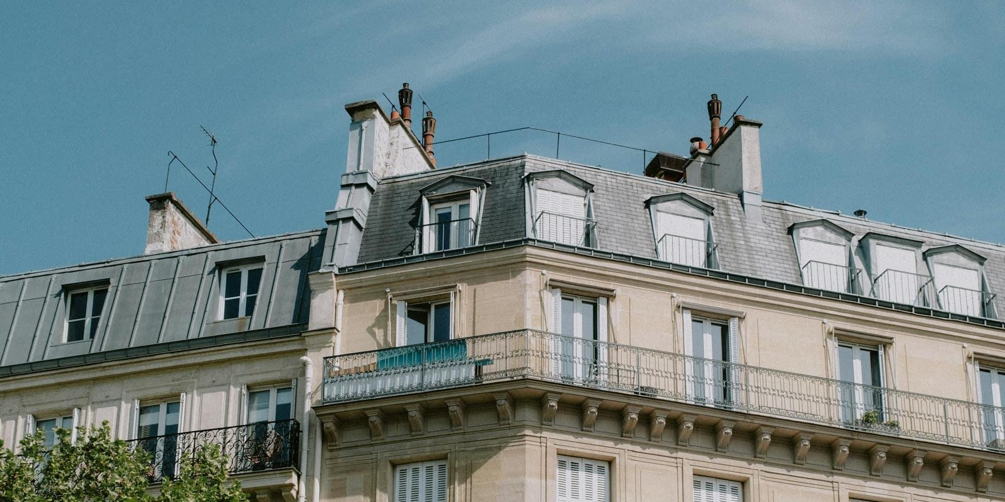 Classic Haussmann apartment facade against a clear blue sky